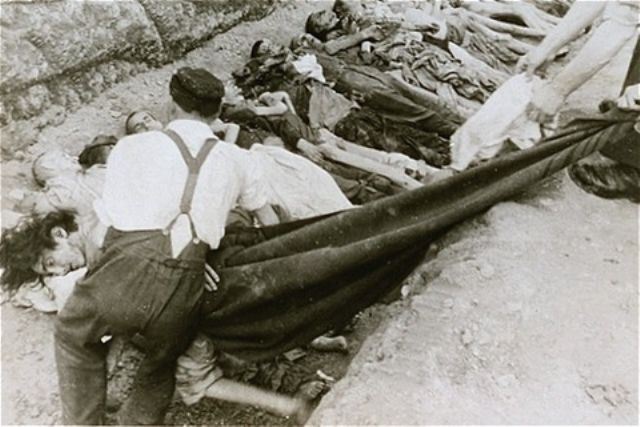 Austrian civilians lay the bodies of former inmates in a mass grave at Mauthausen